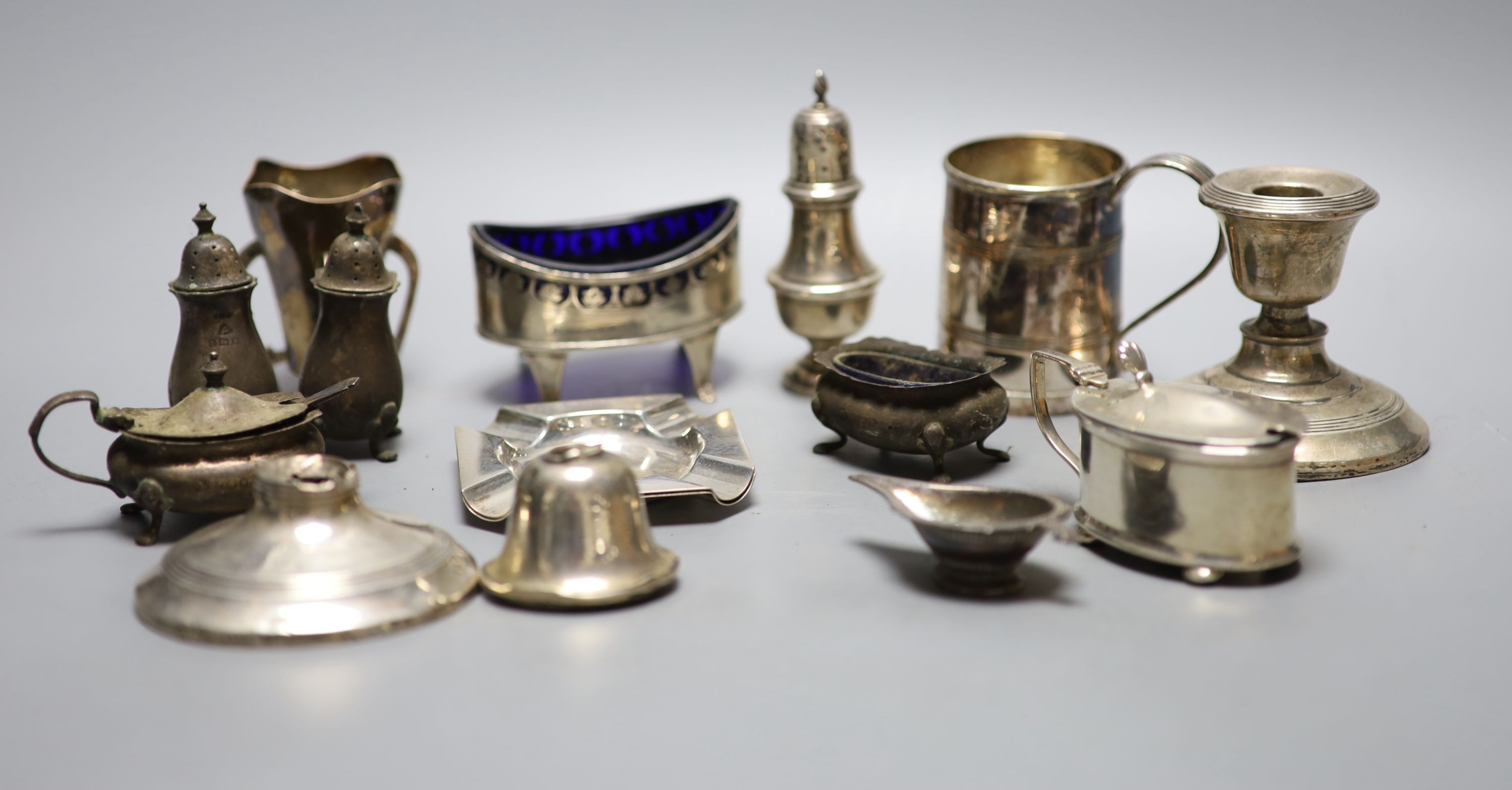 A mixed group of sundry small silver and other items including a pair of silver ashtrays, a small silver vase, silver pepper, damaged dwarf candlesticks, plated mug etc.